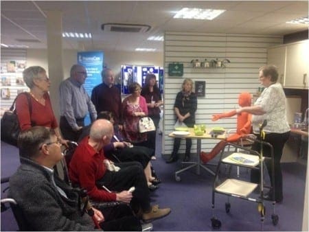 Members of the group listen to OT Jude explaining items to help with managing eating and drinking